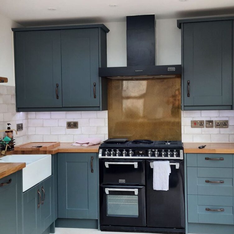gloss finished copper splashback in grey green modern kitchen