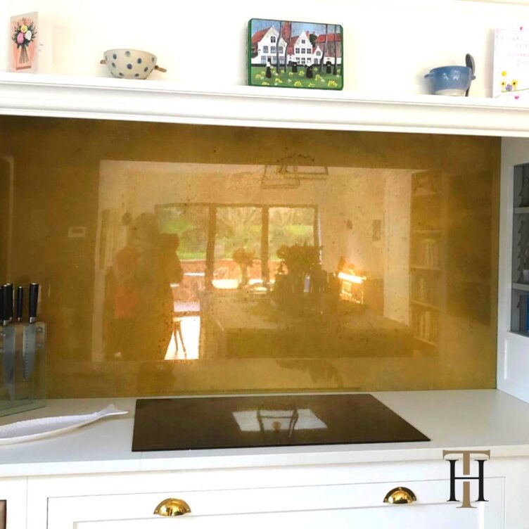 antiqued brass splashback in white kitchen