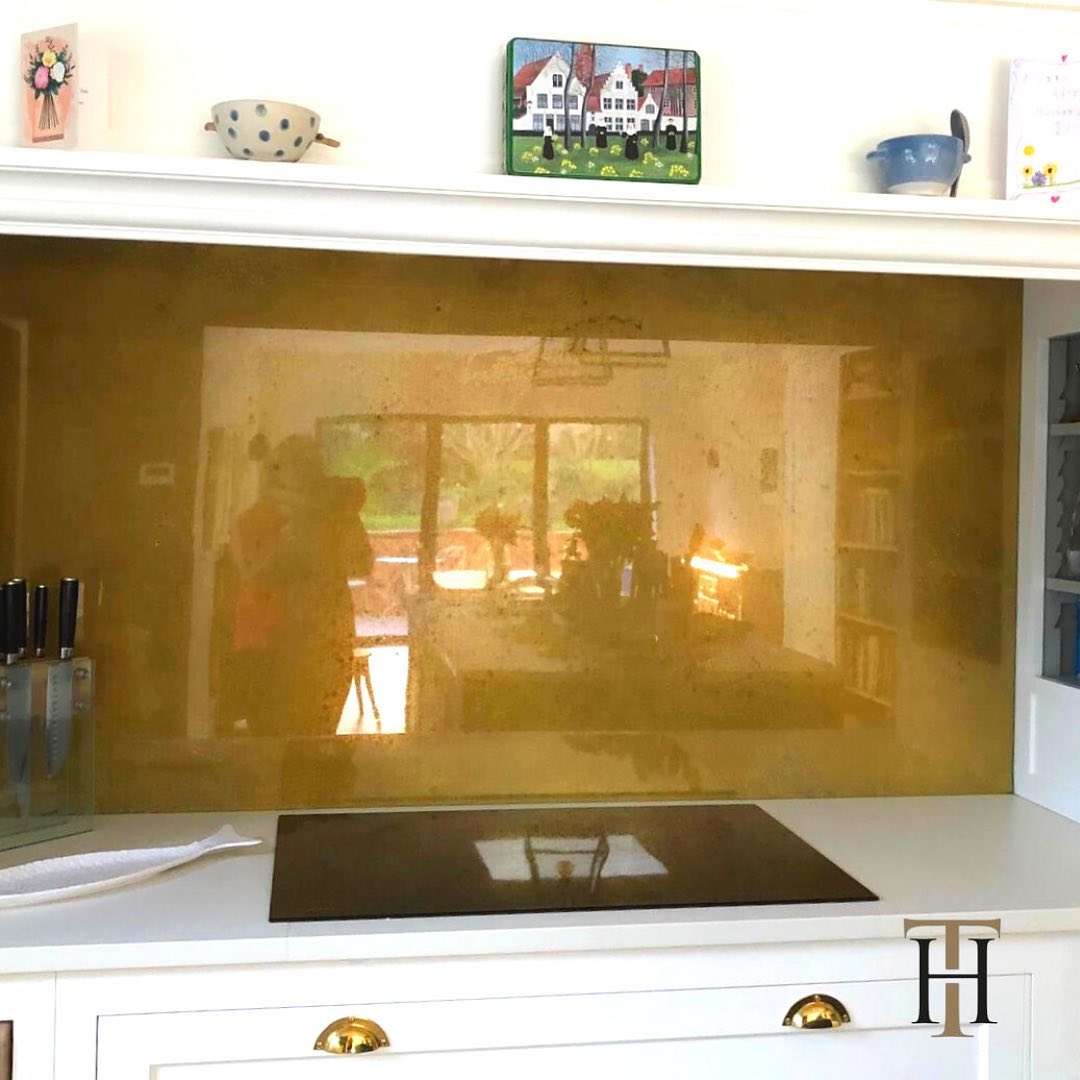 antiqued brass splashback in white kitchen
