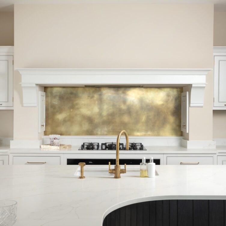 aged patina brass splashback in clean white kitchen