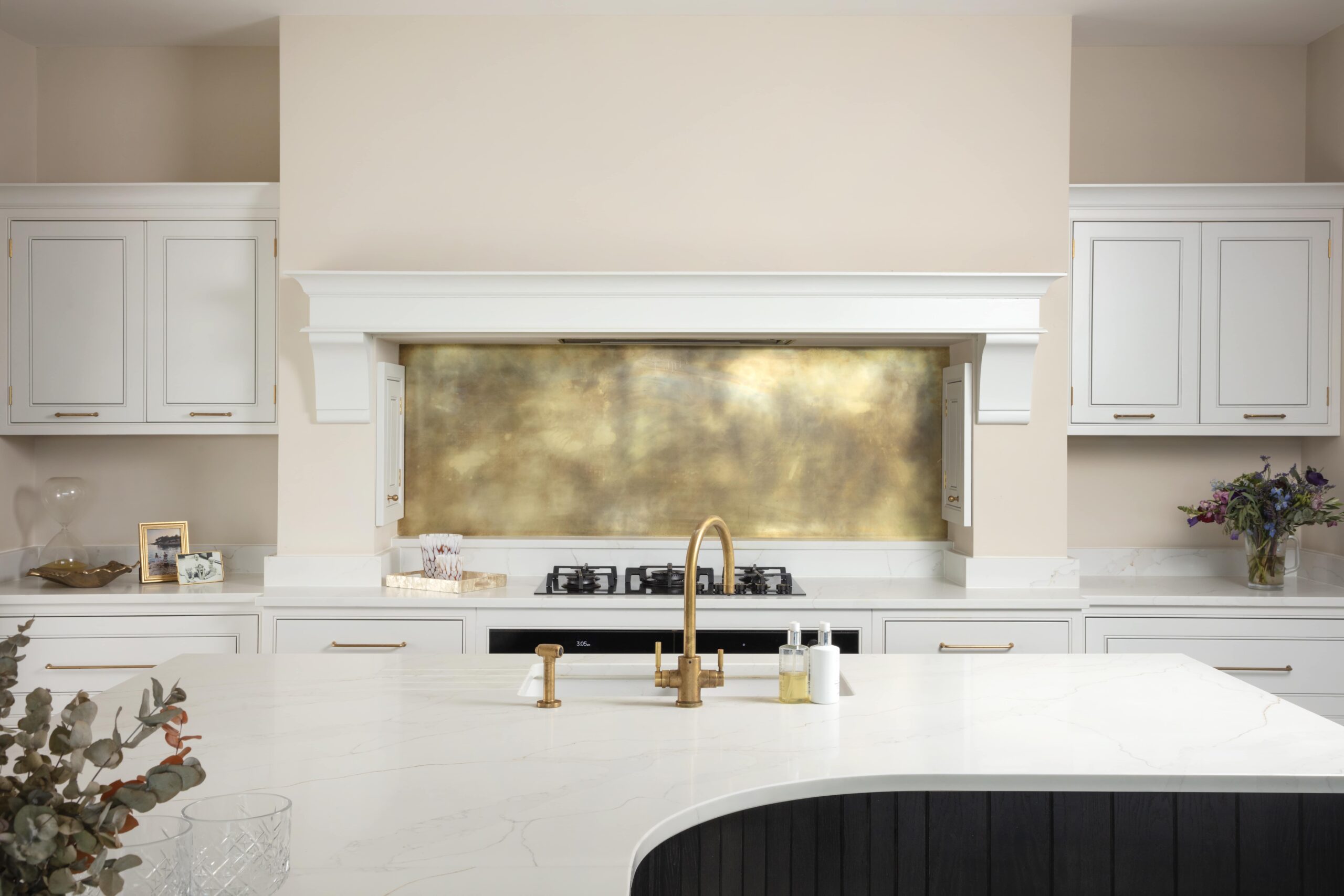 aged patina brass splashback in clean white kitchen