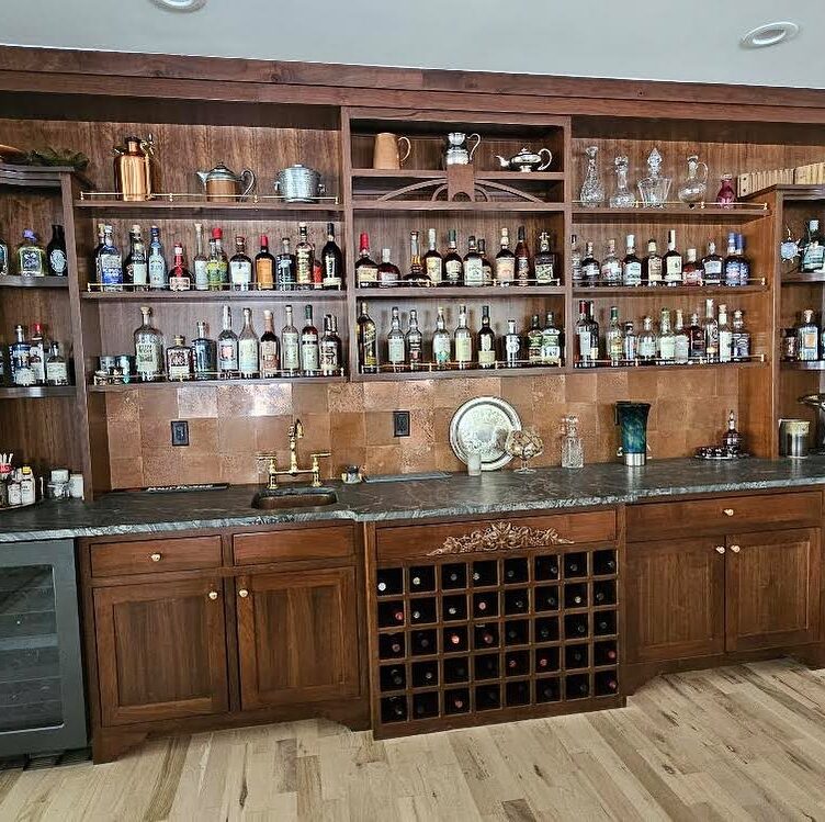 Aged copper tiles used as an alternative to a traditional splashback for an American home bar